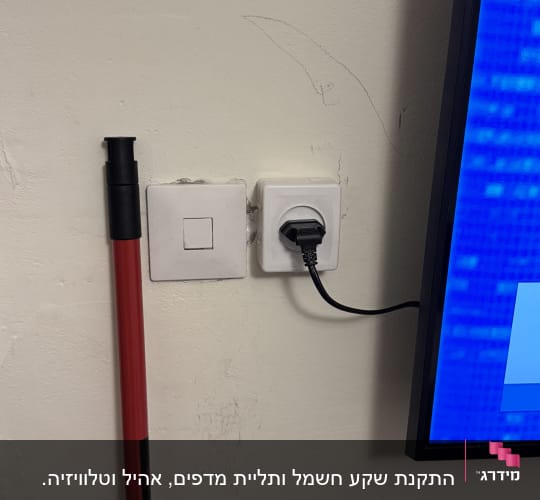 שקע חשמל עם תקע מחובר לקיר